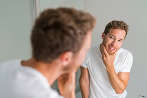 Man looking at his great skin in the mirror