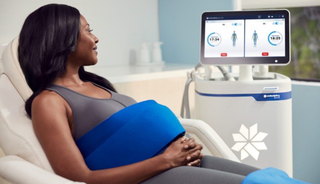 Woman viewing Coolsculpting elite machine while receiving treatment