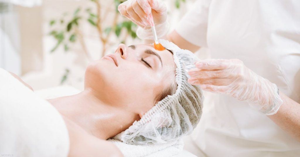 Woman receiving a chemical peel treatment (models)