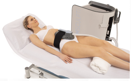 A woman lying on a treatment bed undergoing an Emsculpt Neo procedure to sculpt and tone her body.