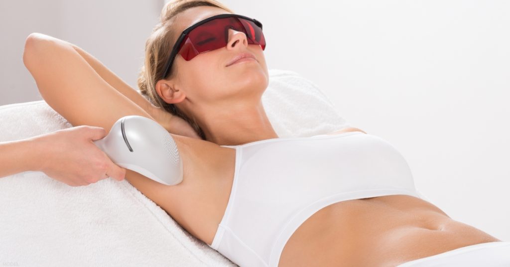 Laser hair removal treatment being performed on a woman (model)